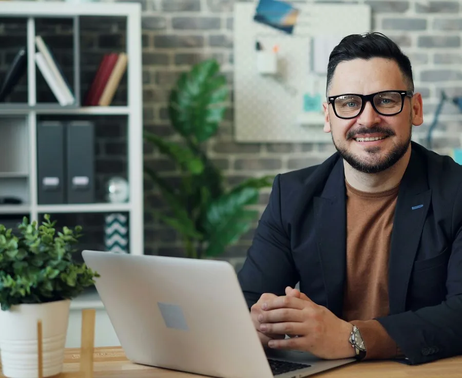 Mann mit Brille am Laptop im Büro